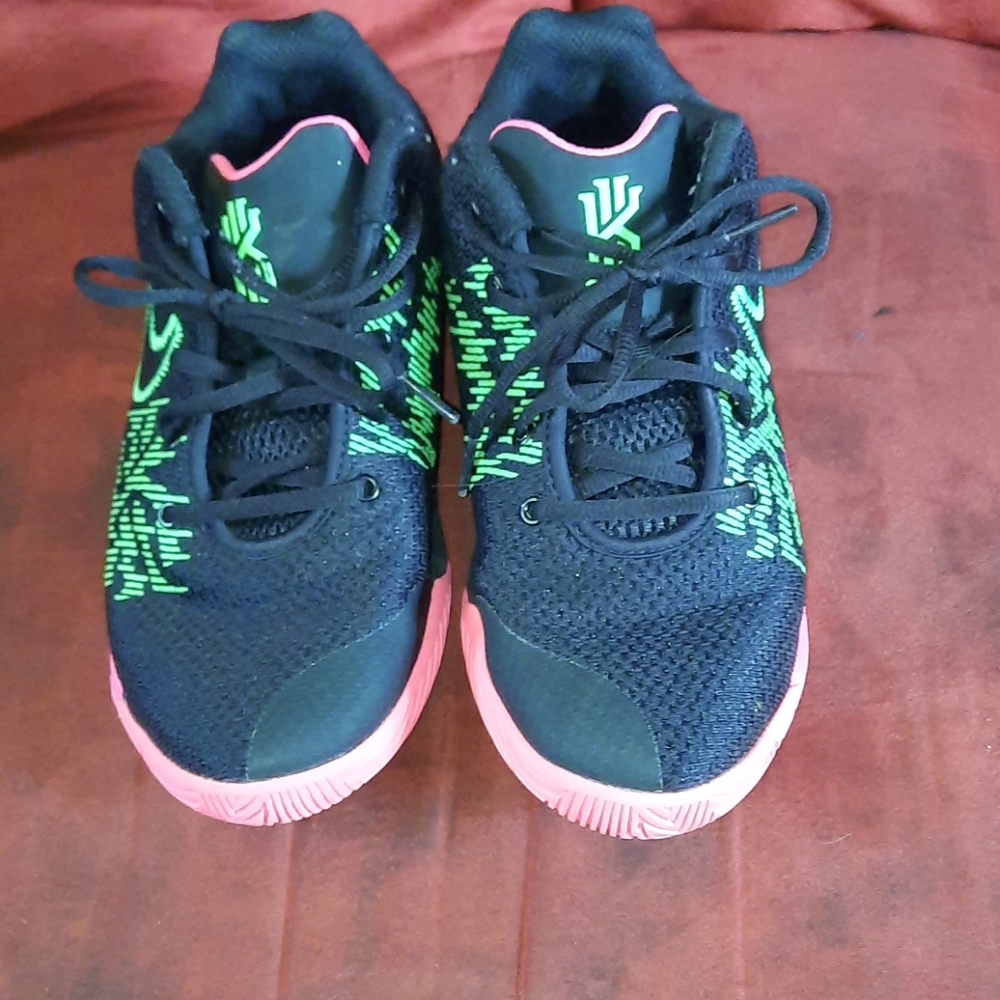 A pair of Black, and green Nike Kyrie Irving